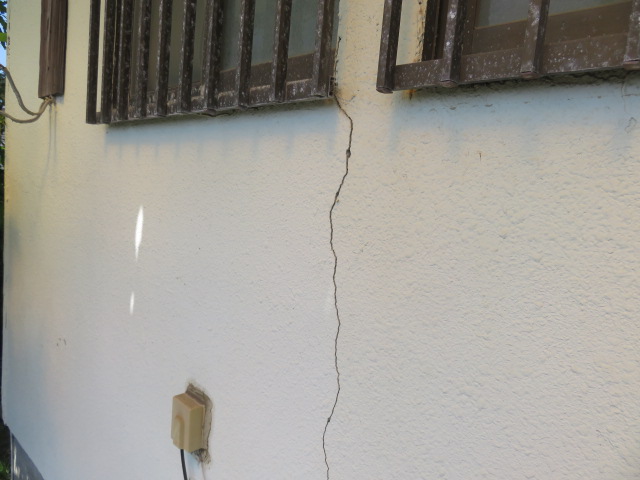 住宅の窓まわりの外壁に発生した縦方向のひび割れ（クラック）